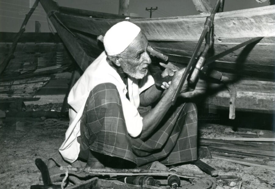 A carpenter working on a traditional fishing boat.jpg